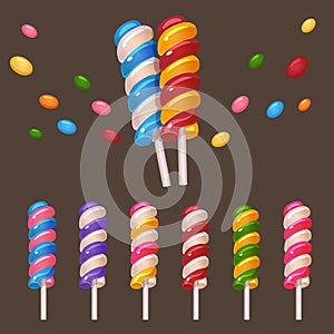 Colored lollipops and candies on white stick set on dark background