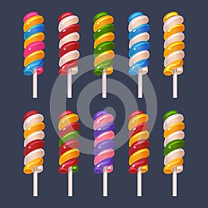 Colored lollipops on white stick set on dark background