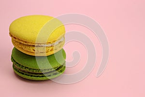 Colored macaroons or macarons on a pink background
