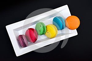 Colored macaroons on a white plate on