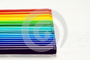 Colored markers without caps lie on a white wooden table