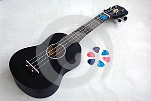 Colored mediators and black ukulele lie on a light background photo