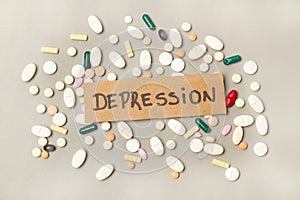 Colored medical pills and capsules and labels with depression word on a white background