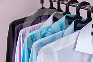 Colored men`s shirts that hang on hangers