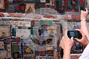 Tourist make a photo of colored mosaic on the wall of the Tbilisi Theater Rezo Gabriadze. photo