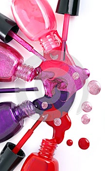 Colored nail polish spilling from bottles photo