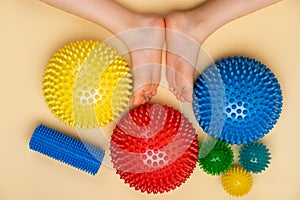 colored needle balancers and balls for massage and physiotherapy on a beige background with the image of a child& x27;s