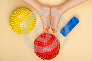 colored needle balancers and a roller for massage and physiotherapy on a beige background with the image of a child