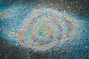 Colored oil stain on the asphalt. A rainbow slick of gasoline.