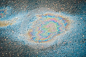 Colored oil stain on the asphalt. A rainbow slick of gasoline.