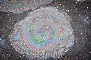 Colored oil stain on the asphalt. A rainbow slick of gasoline.