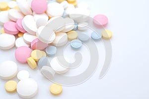 Colored painkiller pills on a blue background and place for text