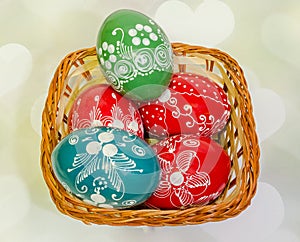 Colored painted romanian traditional Easter eggs in a rustic (vintage) basket, close up