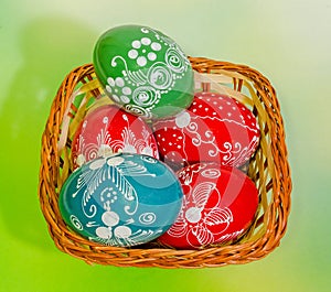 Colored painted romanian traditional Easter eggs in a rustic (vintage) basket, close up