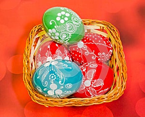Colored painted romanian traditional Easter eggs in a rustic (vintage) basket, close up