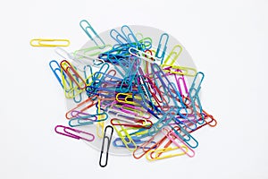 Colored paper clips group on the white desktop background
