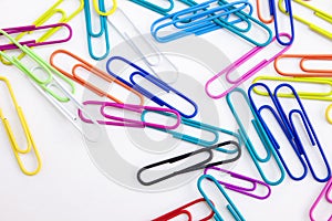 Colored paper clips on white background, Closeup