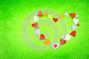 Colored paper hearts on a green cloth