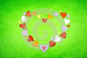 Colored paper hearts on a green cloth