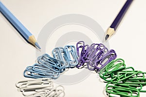 Colored paperclips in a circle and pencils