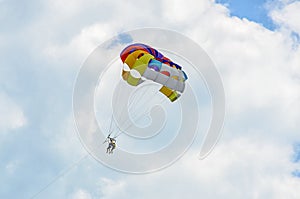 Colored parasail wing in the blue clouds sky, Parasailing