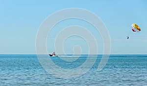 Colored parasail wing pulled by a boat in the sea water, Parasailing