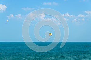 Colored parasail wing pulled by a boat in the sea water, Parasailing also known as parascending or parakiting.