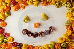 Colored pasta in the form of a spiral. Close-up of raw multi-colored rotini. Smiley. Smile pasta