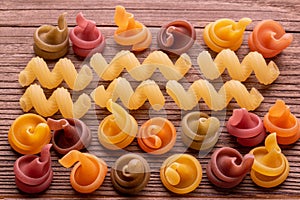 Colored pasta on wooden table