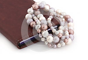 Colored pearls and a mobile phone on a white background.