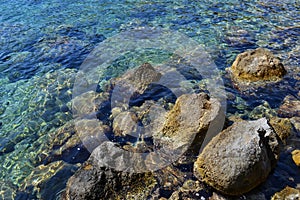 Colored pebbles under water at the coast of Mediterranean sea.