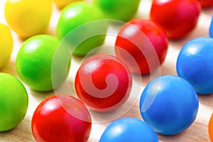 Colored pegs board, wood beads on wooden background. Shallow DOF