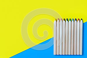 Colored pencils on a blue-yellow background. Copy space, flat layout, mockup. Back to school