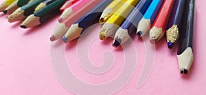 Colored pencils are broken on a pink background. Many different colored pencils. Colored pencil. The pencils are broken