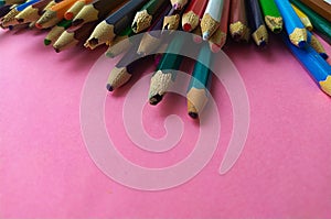 Colored pencils are broken on a pink background. Many different colored pencils. Colored pencil. The pencils are broken