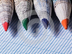 Colored pencils close-up on a background of graph paper