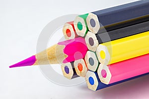 Colored pencils, ends are not sharpened, pink pencil sharpened, on white background, selective focus