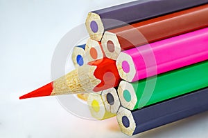 Colored pencils, ends are not sharpened, red pencil sharpened, on white background, selective focus