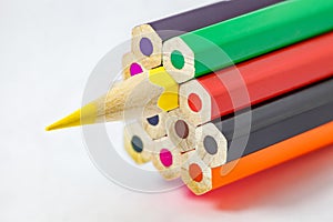 Colored pencils, ends are not sharpened, yellow pencil sharpener, on white background, selective focus