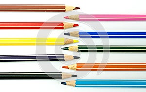 Colored pencils facing each other on a white background