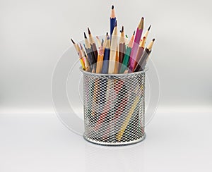 colored pencils in a holder on a white background