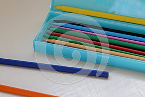 Colored pencils in a light blue pencil case