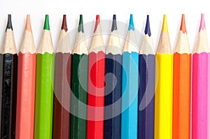 Colored pencils lined up on a white background