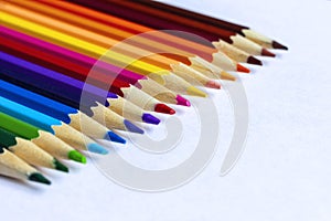 Colored pencils lying in a row on a sheet of paper