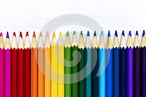 Colored pencils lying in a row on a sheet of paper