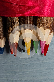 Colored pencils made of natural wood. They are made of unfinished wood on which you can still see the bark