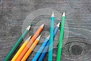 Colored pencils on an old wooden table. Top view. Copy space. Vintage textured background