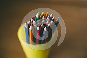 Colored pencils in pencil case on wooden background. Selective focus.