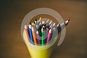 Colored pencils in pencil case on wooden background. Selective focus.