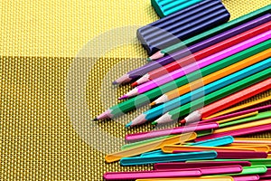 Colored pencils, plasticine and sticks for counting on a bright background